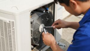 Technician repairing an air conditioner unit outdoors.
