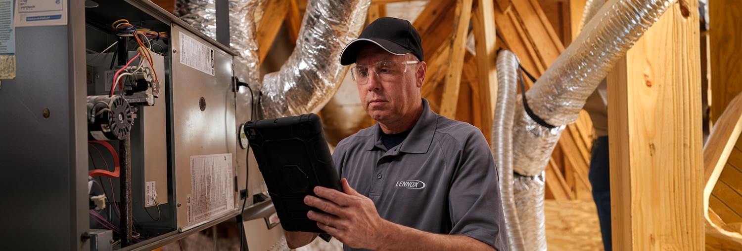 Technician using a digital testing meter while servicing HVAC equipment