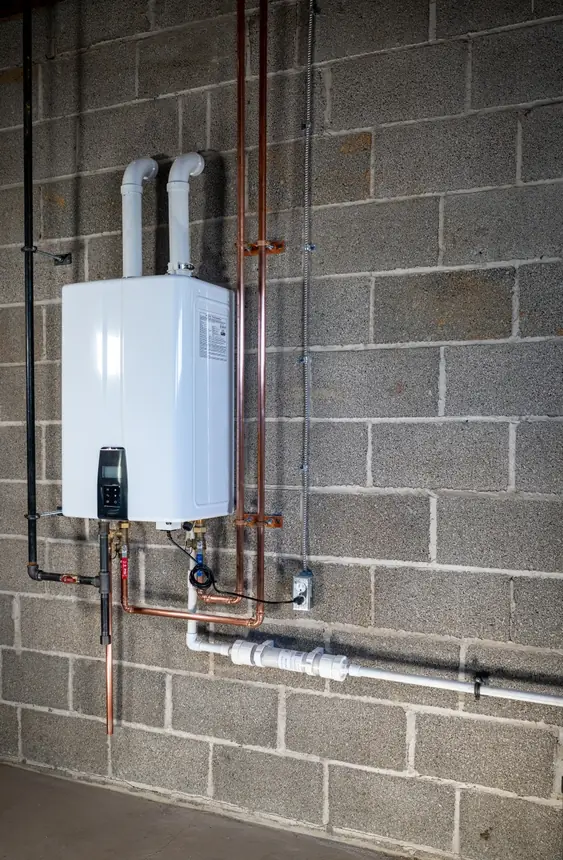 Wall-mounted Navien tankless water heater with neat copper piping on a basement block wall